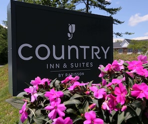 A sign for Country Inn & Suites by Radisson with a logo and name.