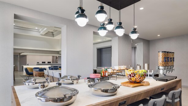 A modern kitchen with a long island, stainless steel appliances, and pendant lighting. - Homewood Suites by Hilton Tulsa South Medical District (Tulsa)