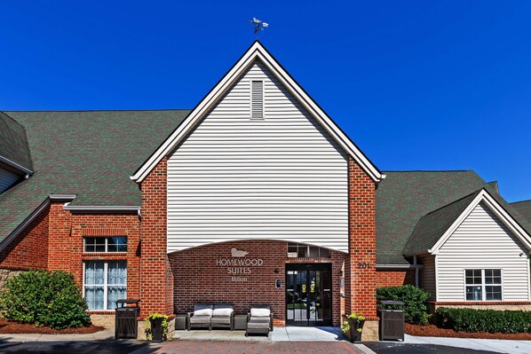 Experience the classic charm of Homewood Suites, where guests can enjoy comfortable outdoor seating areas amidst beautifully maintained surroundings.