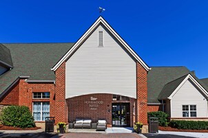 A hotel with a brick facade, a large entrance, and a sign that reads "Homewood Suites Hilton".