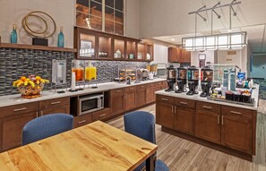 A modern kitchen with a central island, built-in appliances, and a breakfast bar.