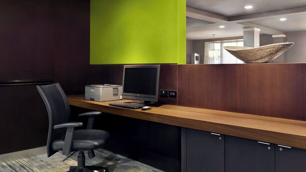 Un espacio de oficina moderno con un escritorio de madera, una computadora y una silla.