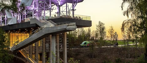 Un edificio moderno con un diseño arquitectónico único, que presenta una sección voladiza y un fachada de vidrio.