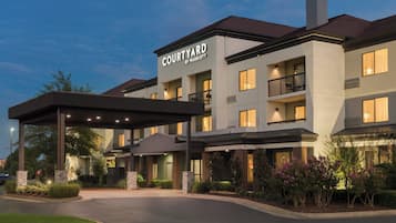 Experience the modern design of this hotel, featuring a covered entrance and balconies on each floor, surrounded by beautifully landscaped gardens.