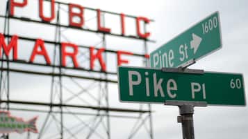 Señales de calle que indican Pine St y Pike Pl, con un cartel grande al fondo que dice 'PUBLIC MARKET'.