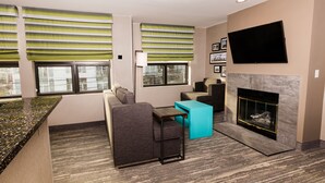 A modern living room with a sofa, a coffee table, and a fireplace. - Hampton Inn & Suites Seattle-Downtown (Seattle)