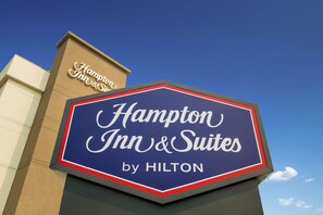 A sign for Hampton Inn & Suites by Hilton.