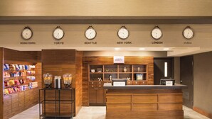 A hotel lobby with clocks displaying times from six cities, a snack bar, and a reception desk. - Four Points by Sheraton Downtown Seattle Center (Seattle)