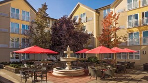 A courtyard with outdoor seating, a central fountain, and red umbrellas. - Four Points by Sheraton Downtown Seattle Center (Seattle)