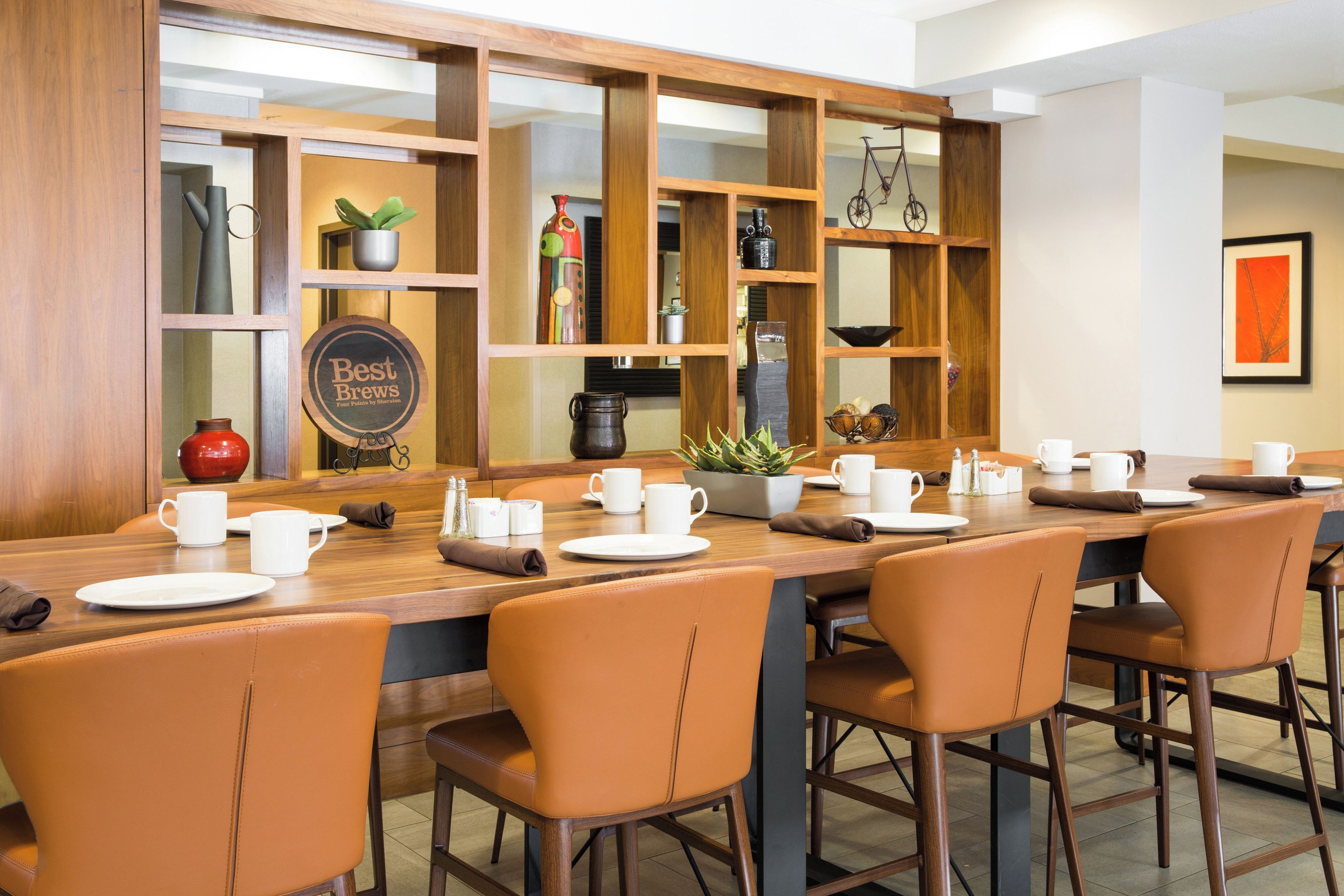 Un restaurante con una barra de madera larga y varias zonas de estar.