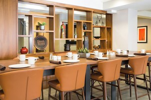 Un restaurante con una barra de madera larga y varias zonas de estar.