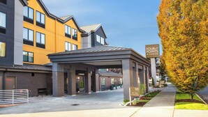 A hotel entrance with a covered outdoor area, a sign indicating 'Four Points by Sheraton', and a tree with autumn leaves. - Four Points by Sheraton Downtown Seattle Center (Seattle)