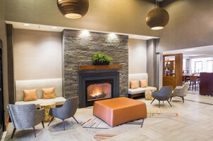 Un vestíbulo moderno con chimenea de piedra, zona de estar y comedor.
