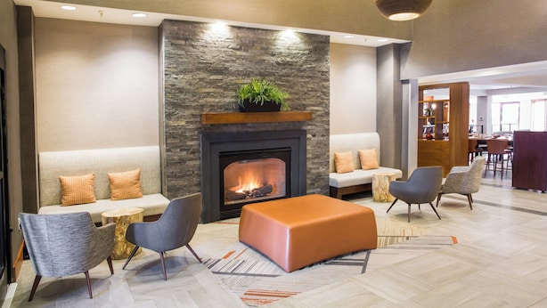 A modern lobby with a fireplace, seating area, and dining space. - Four Points by Sheraton Downtown Seattle Center (Seattle)