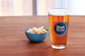 A glass of beer with a label reading "Best Brews" next to a bowl of popcorn on a wooden table. - Four Points by Sheraton Downtown Seattle Center (Seattle)