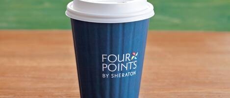 A blue disposable cup with a white lid and the text "FOUR POINTS BY SHERATON" on it.