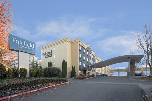 Um hotel Fairfield Inn & Suites com design moderno, entrada coberta e área de estacionamento.