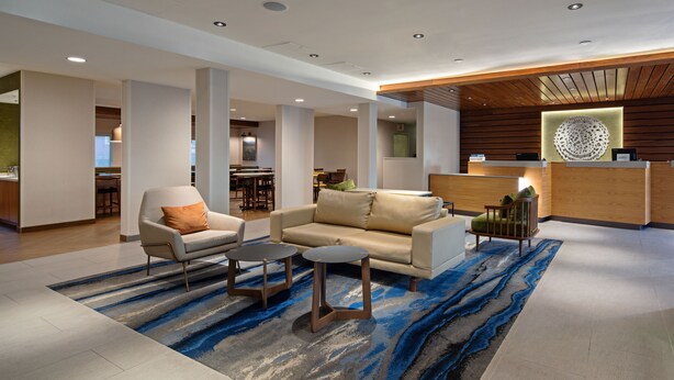 A modern lobby with a reception desk, seating area, and a dining space. - Fairfield by Marriott Inn & Suites Seattle Sea-Tac Airport (SeaTac)