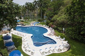Una piscina al aire libre, sombrillas, sillones reclinables de piscina
