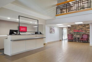 A hotel reception area with a counter, a sign indicating free Wi-Fi, and a reception desk. - Red Roof Inn San Antonio - Seaworld/ Northwest (San Antonio)