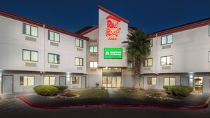 A hotel with a Red Roof Inn sign, HomeTown Studios, and a well-lit entrance. - Red Roof Inn San Antonio - Seaworld/ Northwest (San Antonio)