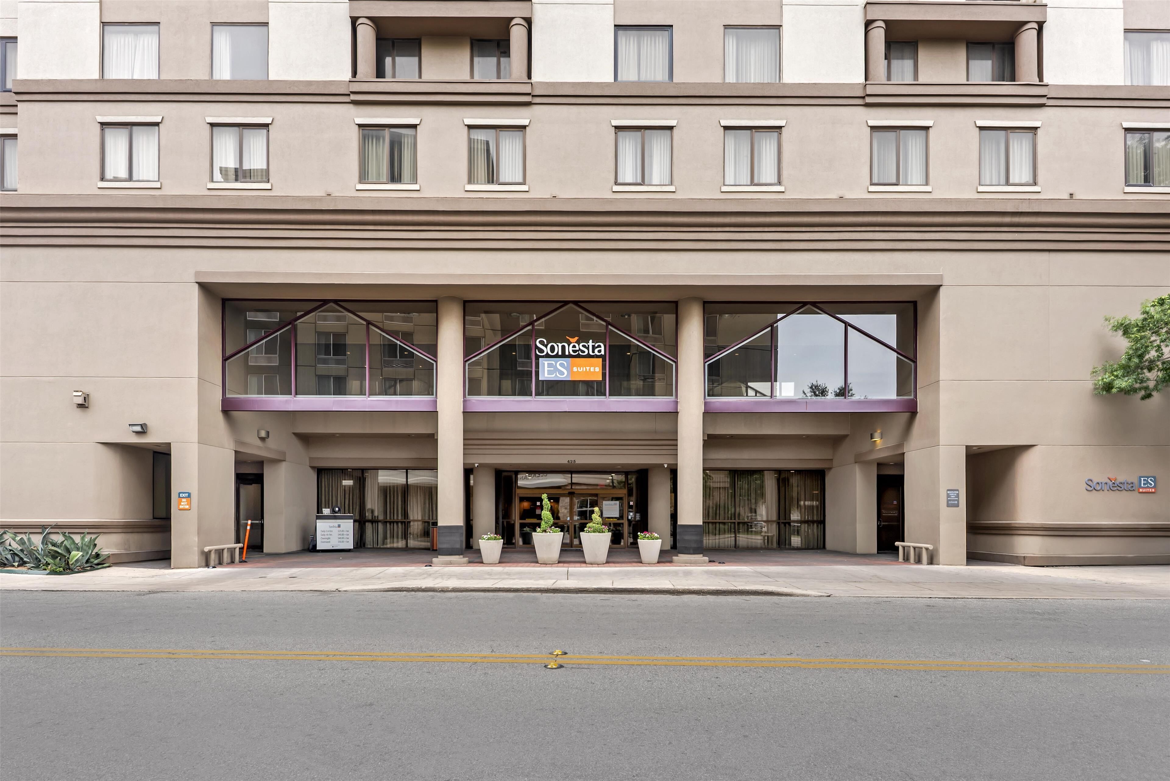 Een hotelingang met een bord waarop 'Sonesta ES Suites' staat.