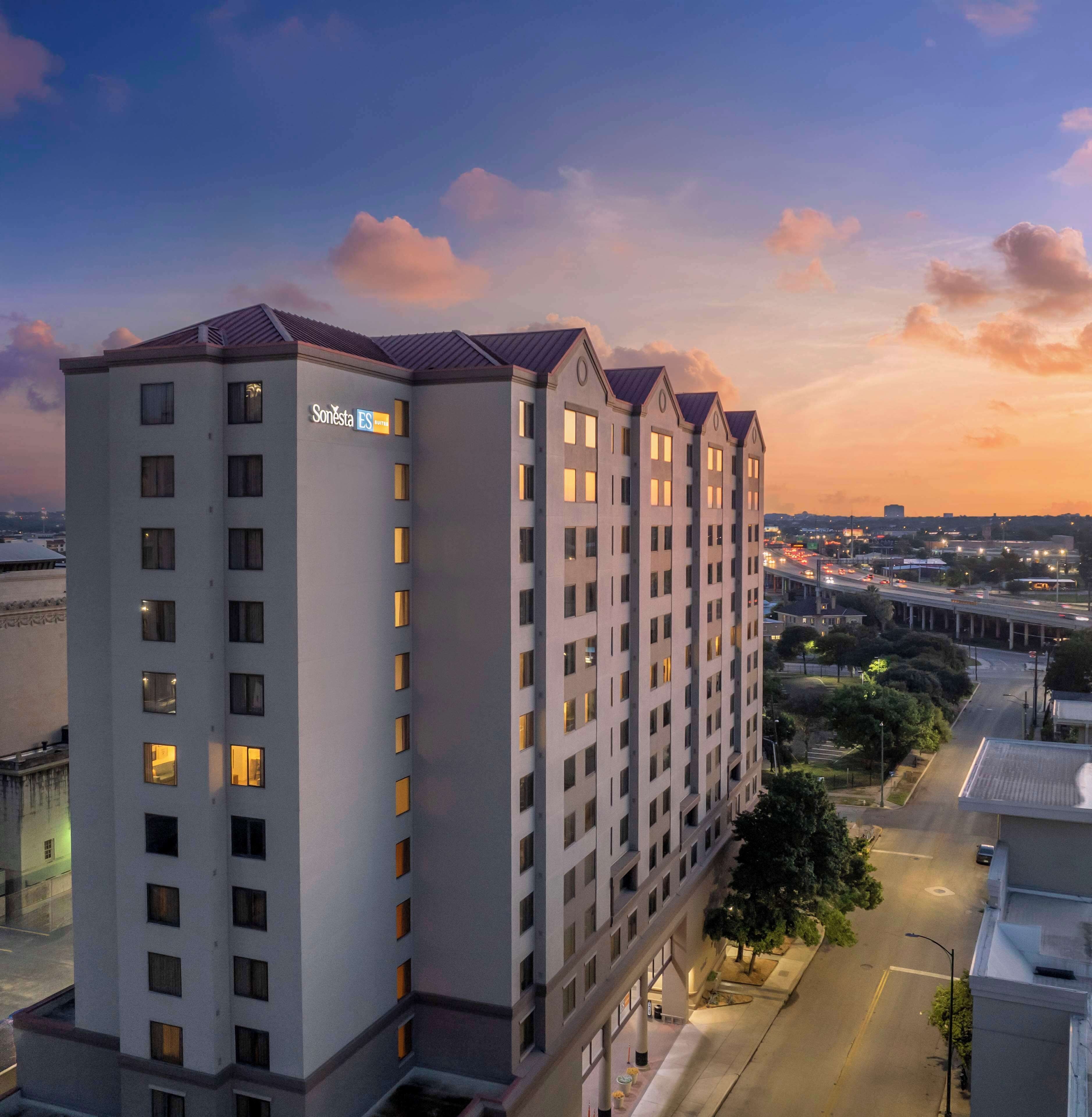 A multi-story hotel with a modern architectural design, featuring a prominent 'Sonesta' sign on the facade.