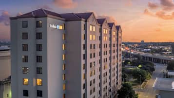 A multi-story hotel with a modern architectural design, featuring a prominent 'Sonesta' sign on the facade.