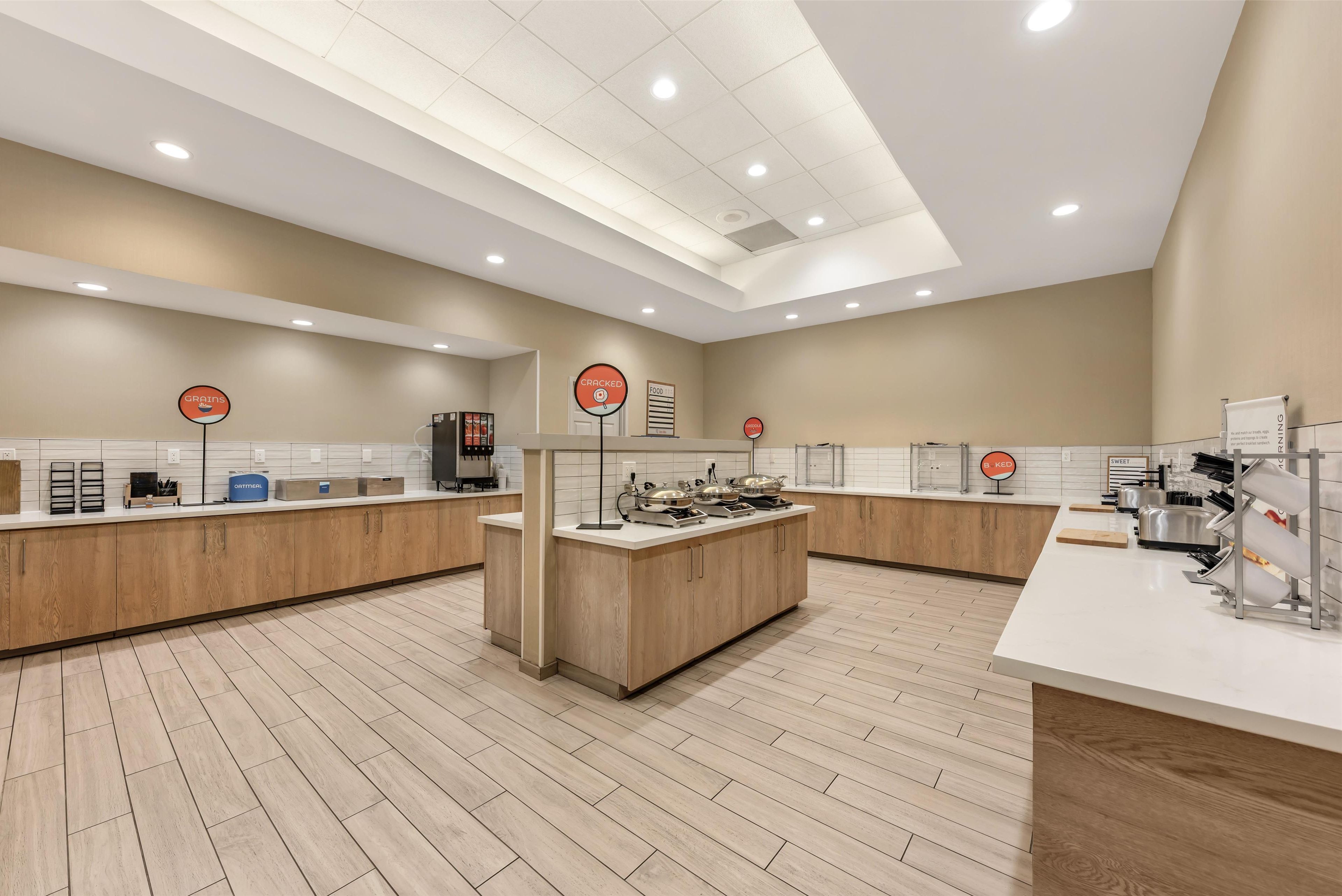 Una cocina moderna con armarios de madera, una isla central y diversos electrodomésticos.