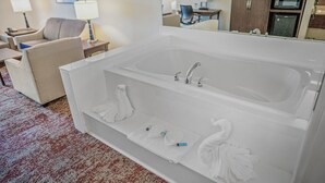 Un baño moderno con una bañera grande, dos lavamanos y un espejo.