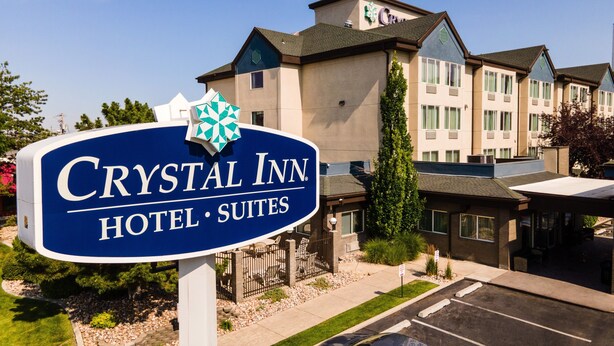 Señal para Crystal Inn Hotel Suites, con un edificio moderno de fondo.