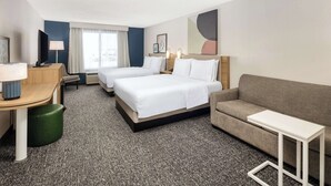 A hotel room with two beds, a sofa, a desk, and a TV. - Spark by Hilton Salt Lake City Airport (Salt Lake City)