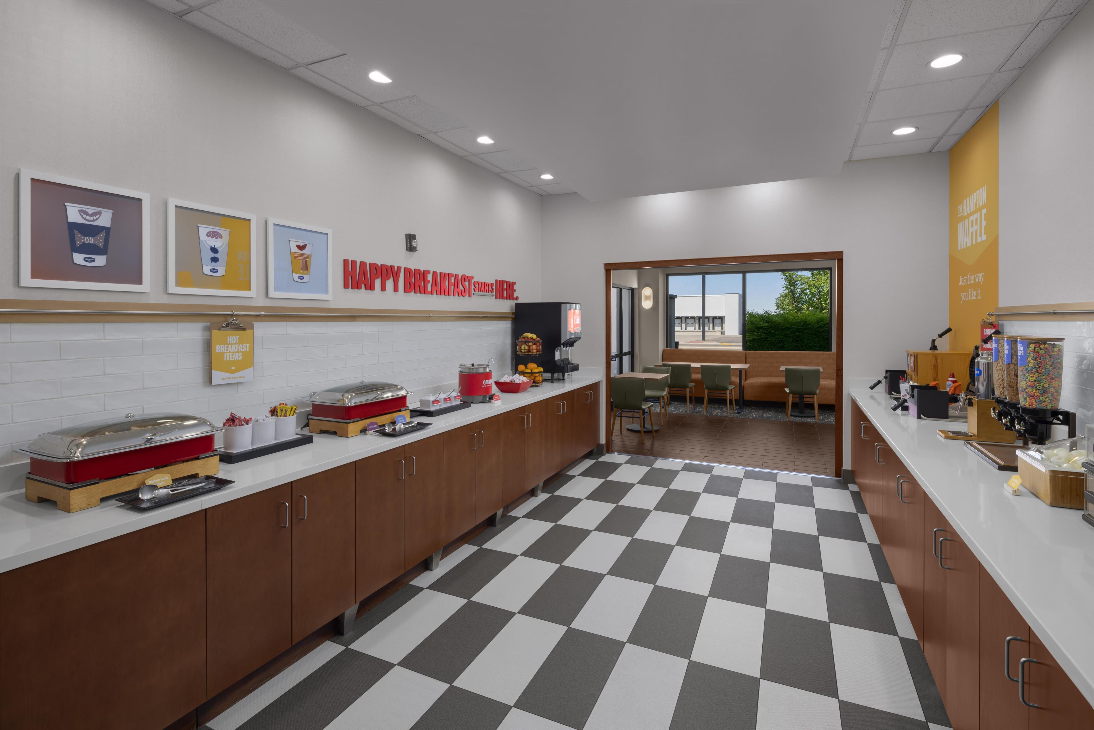 A breakfast bar with a checkered floor, a counter with food items, and a sign that says 'HAPPY BREAKFAST SHARE HERE.'