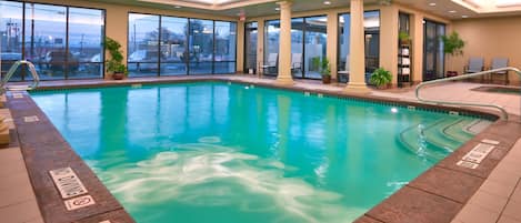 Piscina interior con agua cristalina, un cartel que indica 'no buceo' y una marca de profundidad de 0.9 metros.
