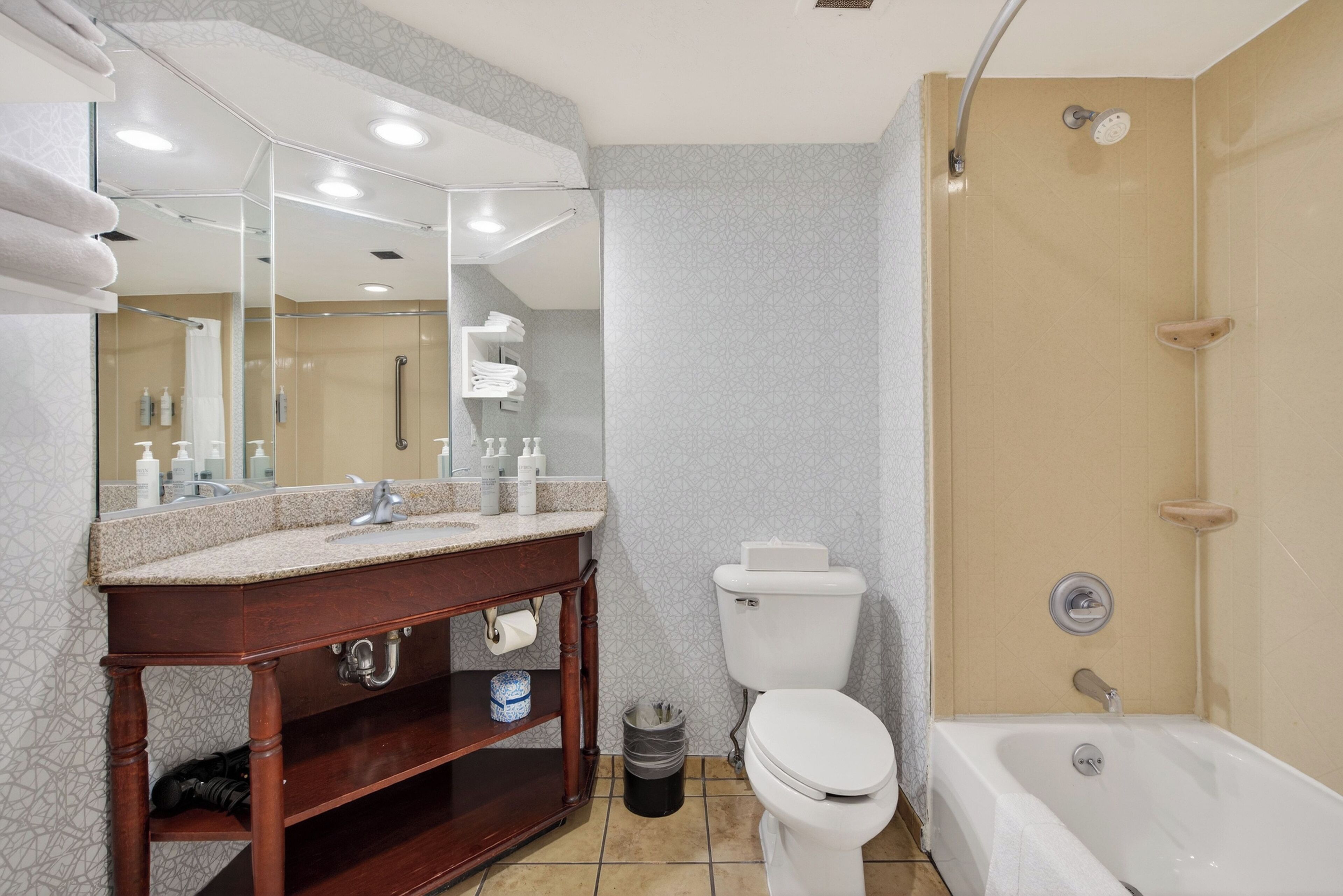 Une salle de bain moderne équipée d’un meuble-lavabo, de toilettes et d’une baignoire.