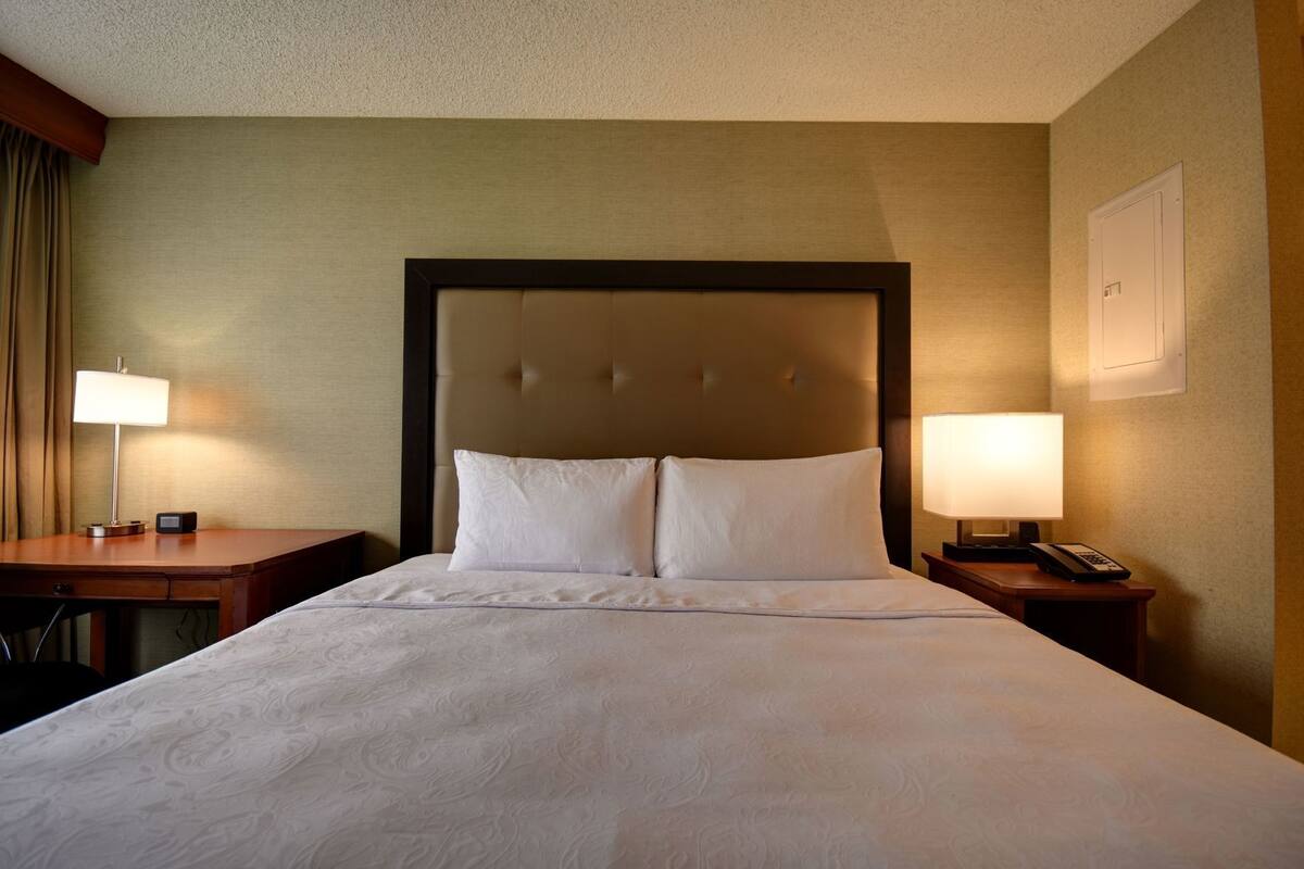 1 habitación, escritorio y tabla de planchar con plancha