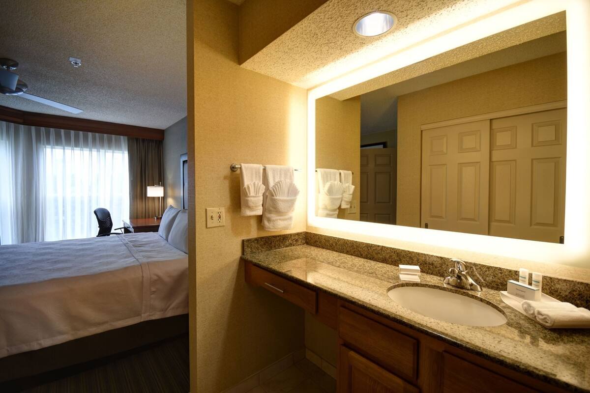 1 habitación, escritorio y tabla de planchar con plancha