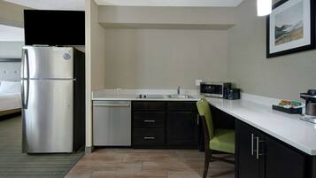 A compact hotel kitchen with a refrigerator, microwave, and coffee maker.