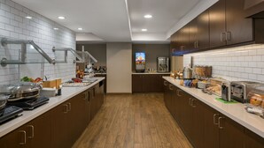 A modern kitchen with stainless steel appliances, wooden cabinets, and a tiled backsplash.