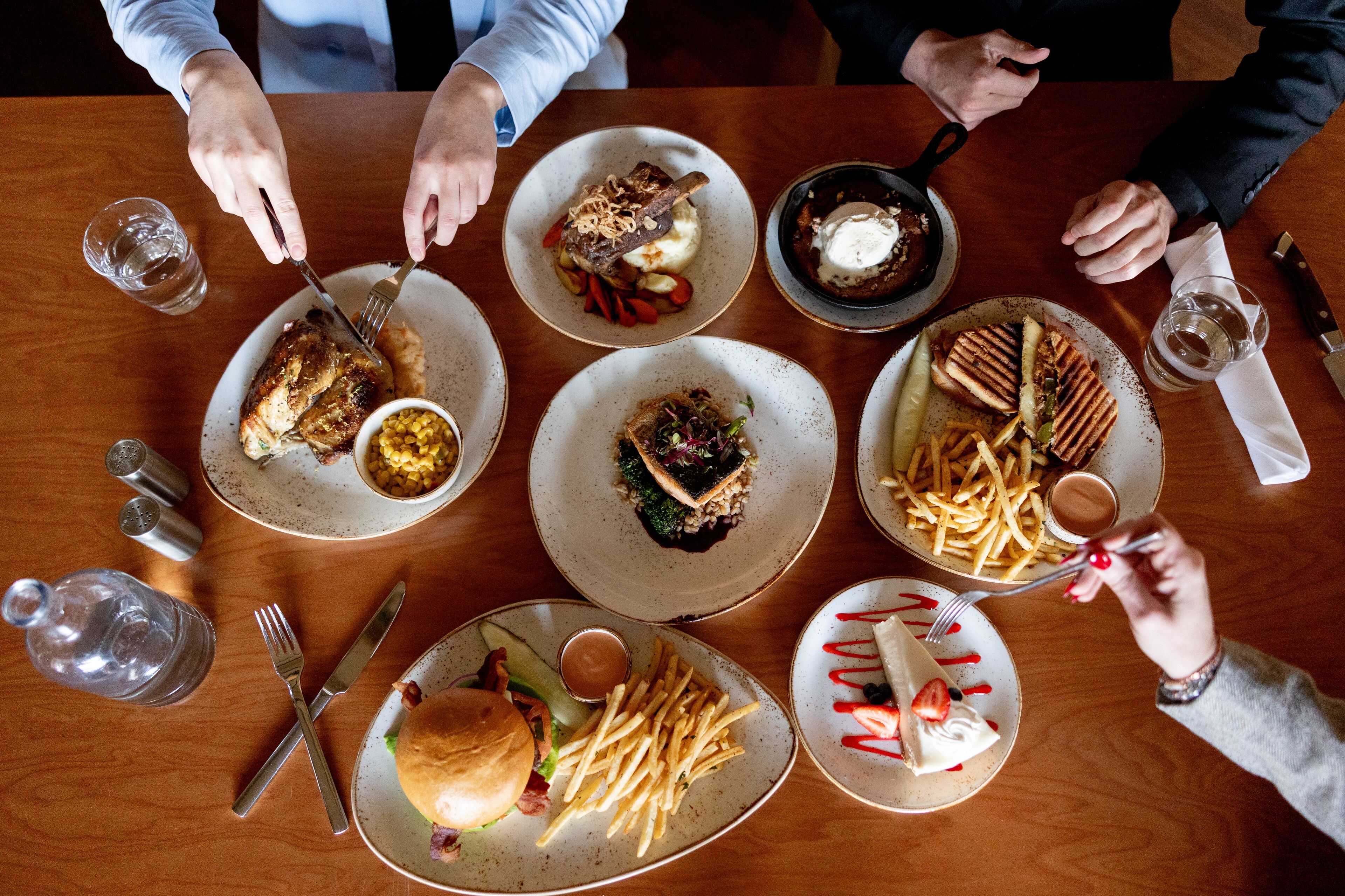 A dining table with various dishes, utensils, and condiments.