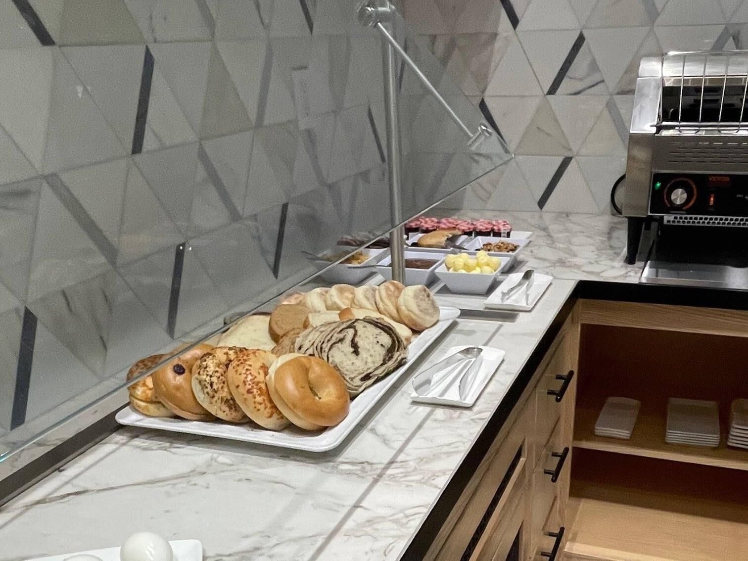 Un bufé de desayuno con diversos pasteles y una cafetera.
