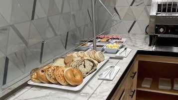 Un bufé de desayuno con diversos pasteles y una cafetera.