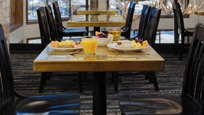 A breakfast setting with a table, chairs, and a view of the outdoors. - The Rockwell Inn (Jackson)