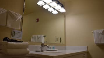 A bathroom with a sink, mirror, and towel rack.