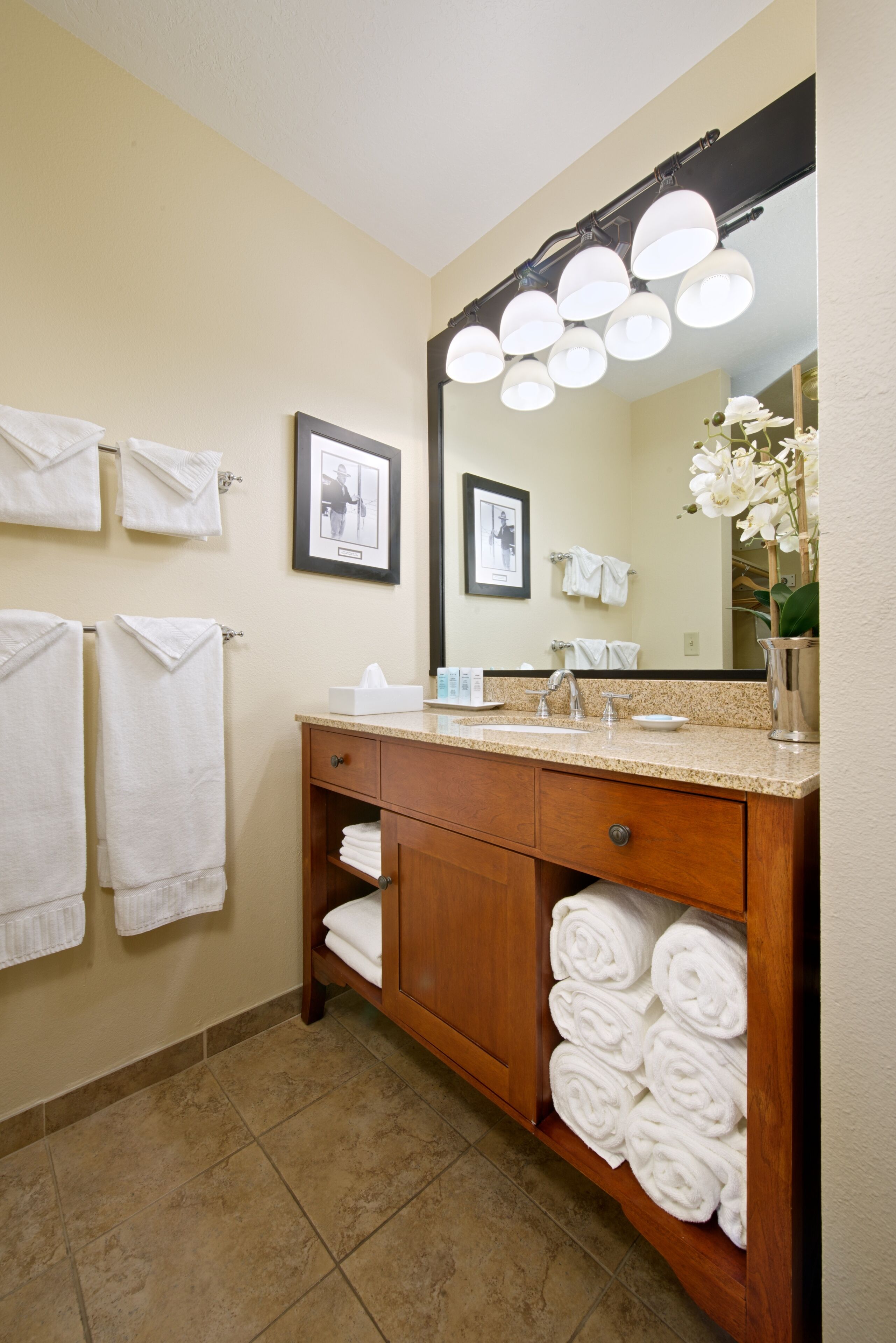 Un bagno con un mobile bagno in legno, uno specchio grande e diversi asciugamani.