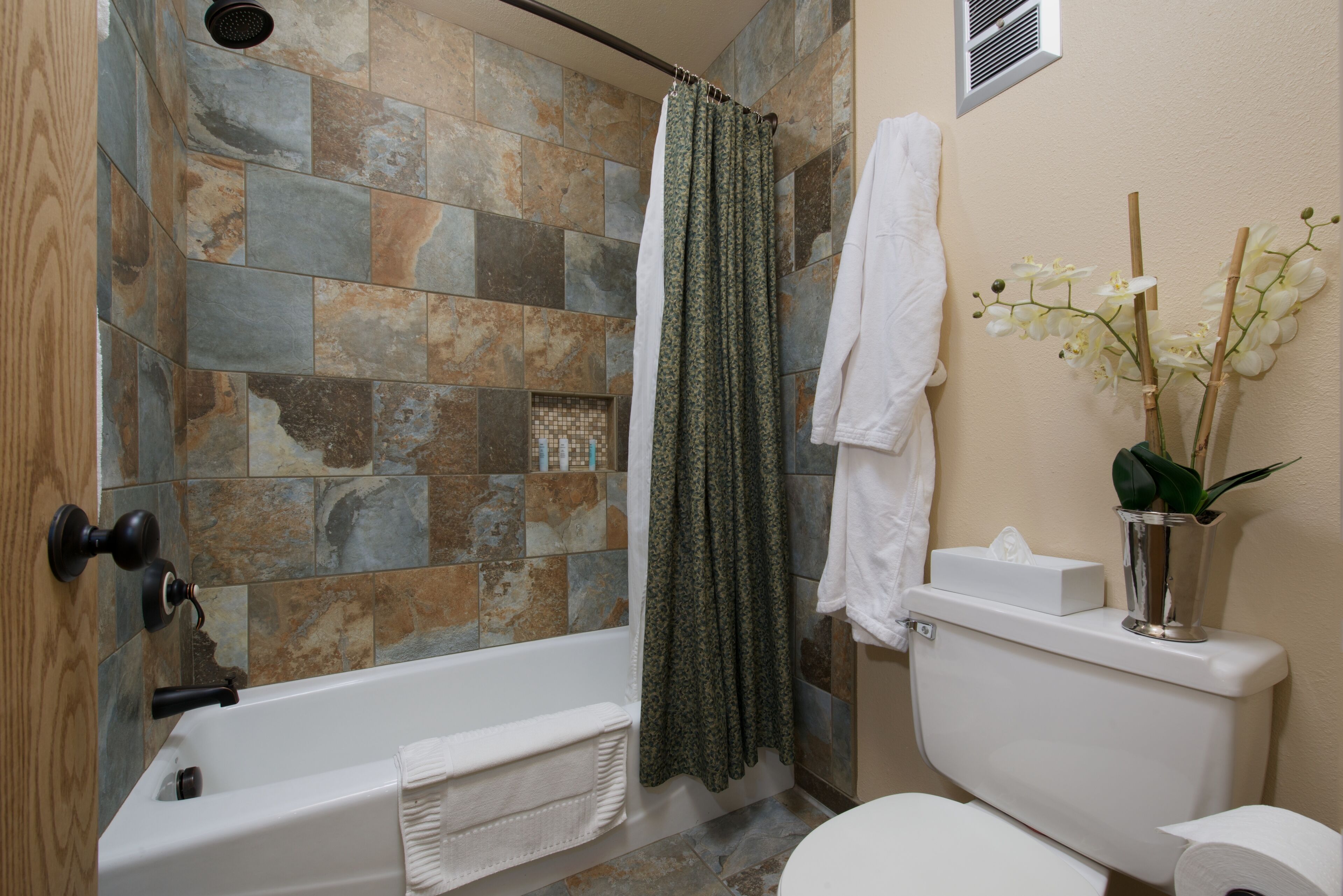 A bathroom with a bathtub, toilet, and shower curtain.