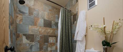 A bathroom with a bathtub, toilet, and shower curtain.