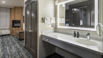 A modern bathroom with a large mirror, a sink, and a towel rack.