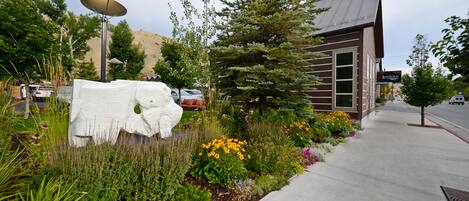 A building with a modern design, surrounded by a landscaped garden with various plants and flowers.