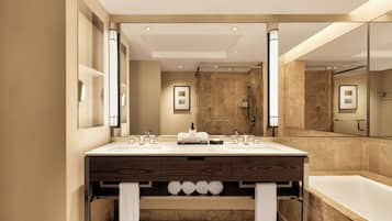 A modern bathroom with a large mirror, two sinks, a bathtub, and a shower.